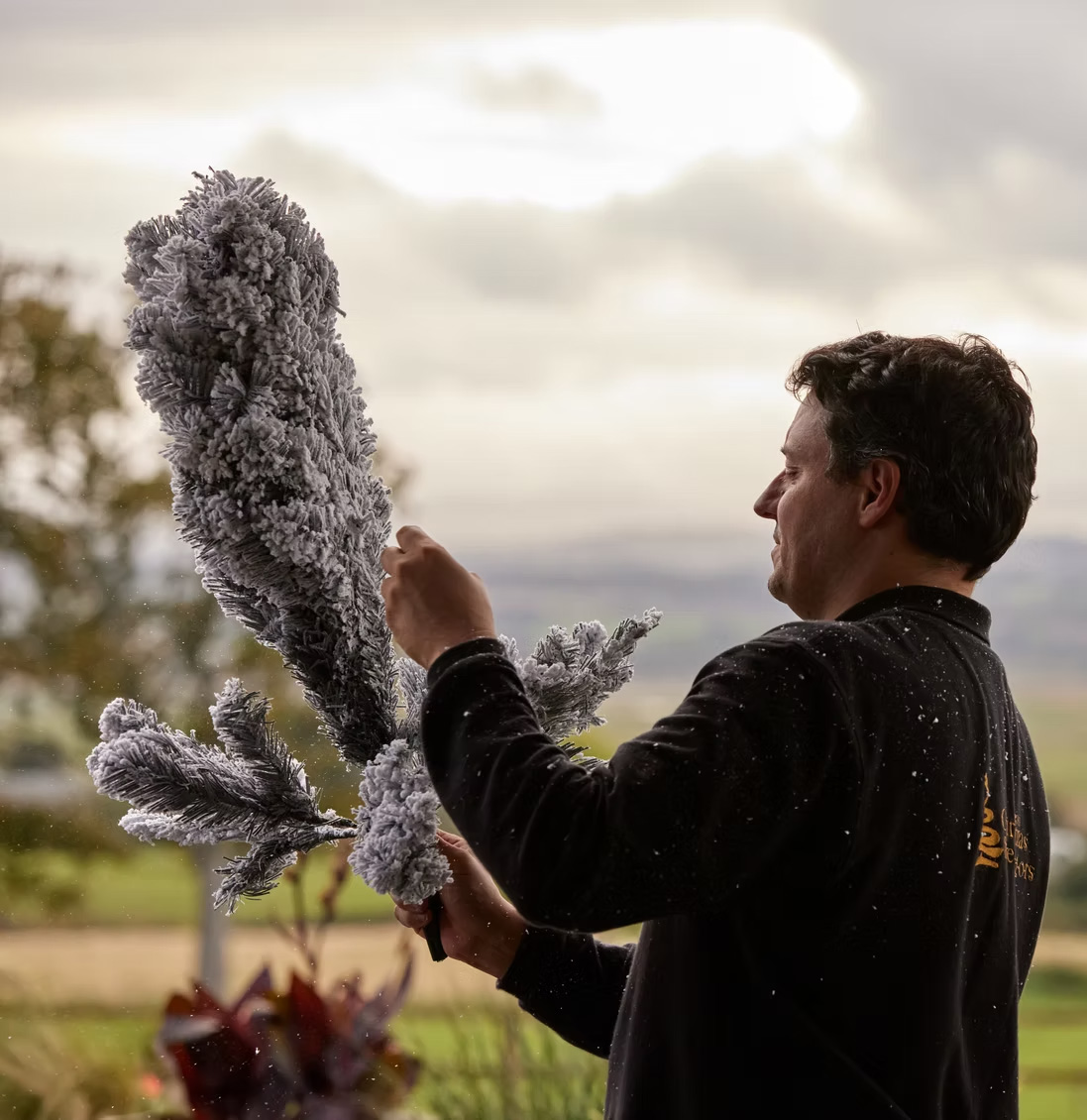 A member of the decorating team preparing garland outdoors